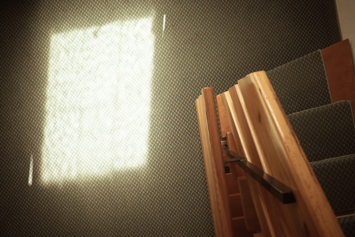 Sonnenlicht auf dem Treppenabsatz und Holzgeländer im Haus