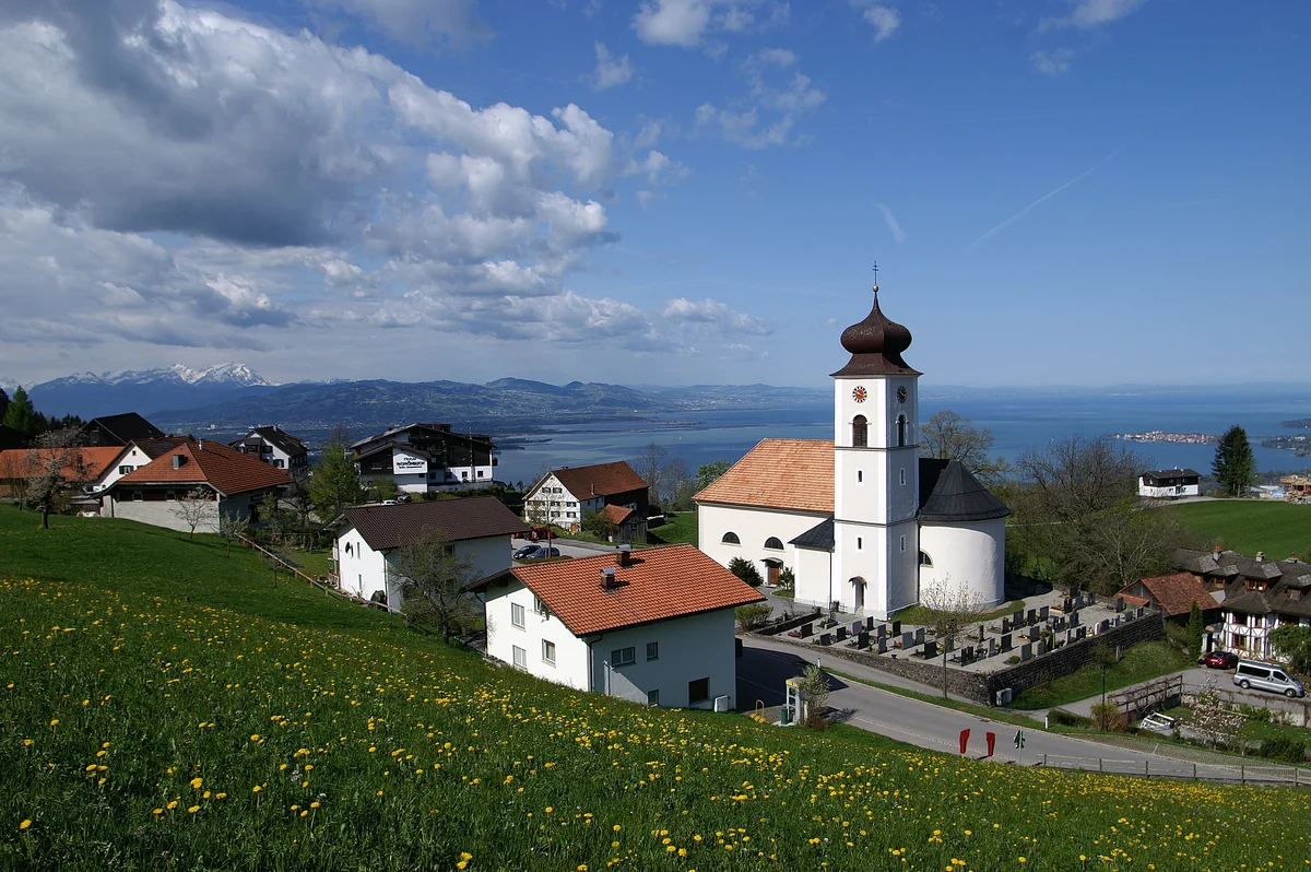 Eichenberg mit der Kirche St. Bernhard, grünen Wiesen und weitem Blick über den Bodensee